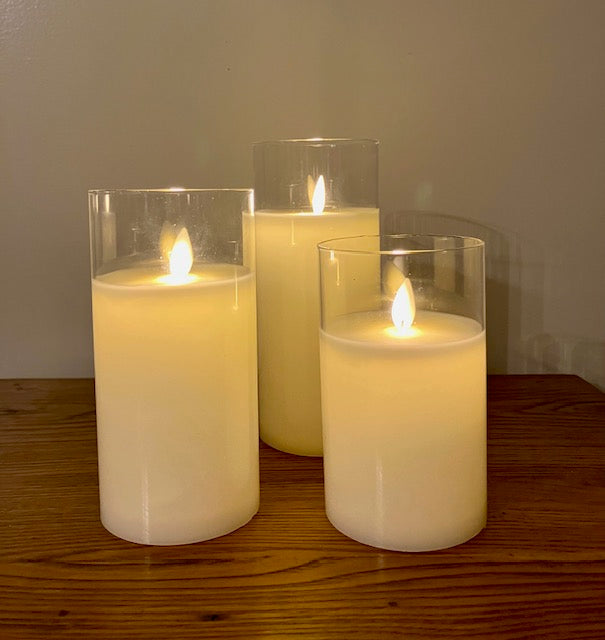 Set of 3 cream color candles in glass. Realistic look moving flame