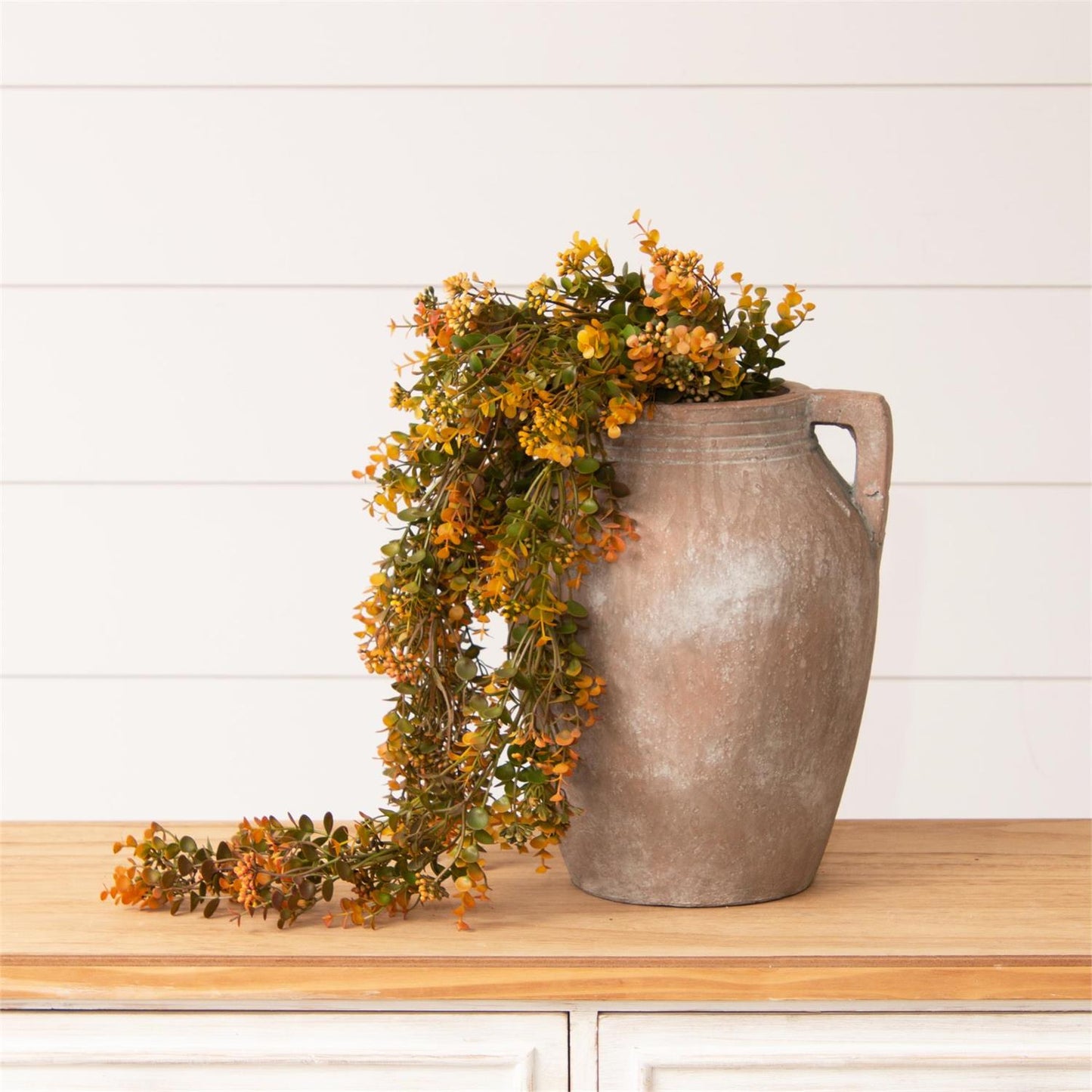 Cascading mustard greenery stem with mustard flowers and green leaves. 