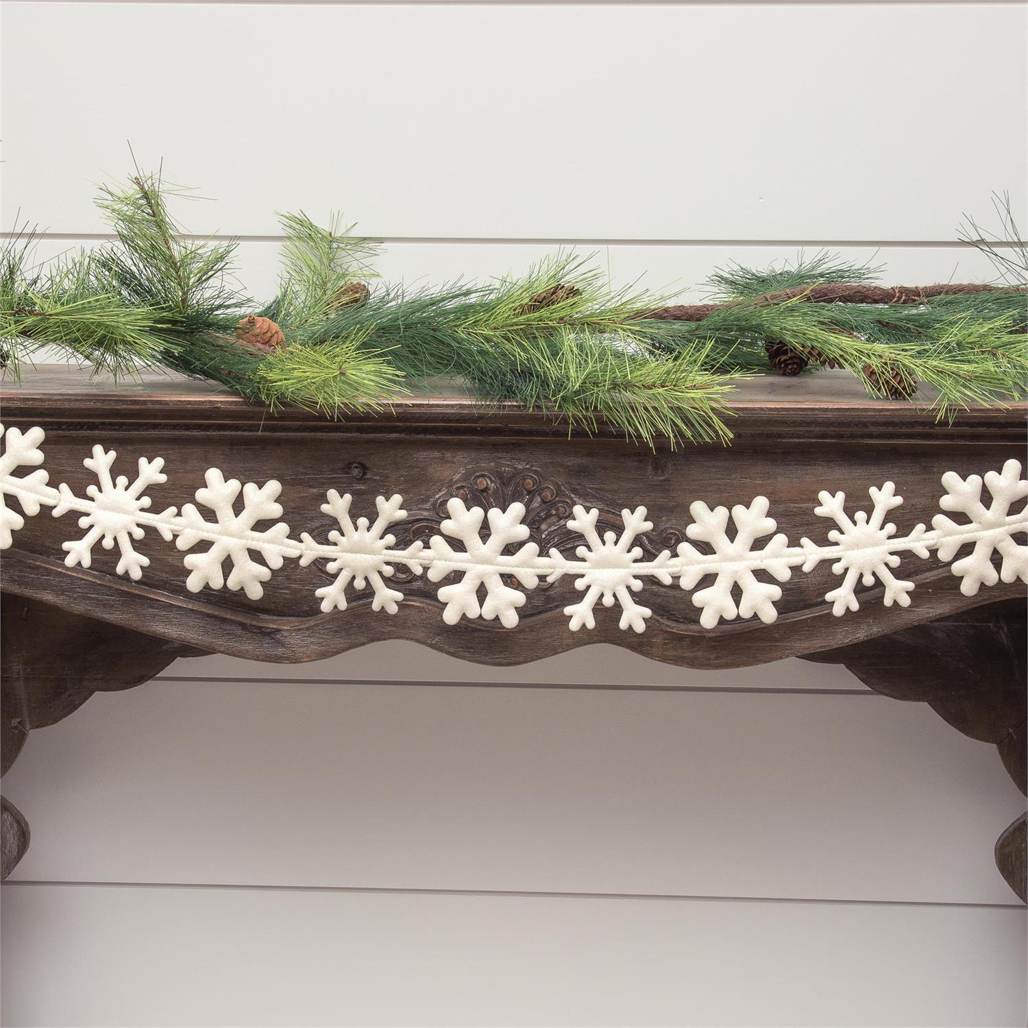 White snowflake garland with intricate snowflakes to adorn a fireplace mantle or tabletop display.