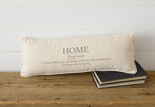 A cream color cotton fabric lumbar pillow measures 8" x 22" with the definition of  what a home means. HOME, A place where you are always welcome and surrounded by those who love you. 