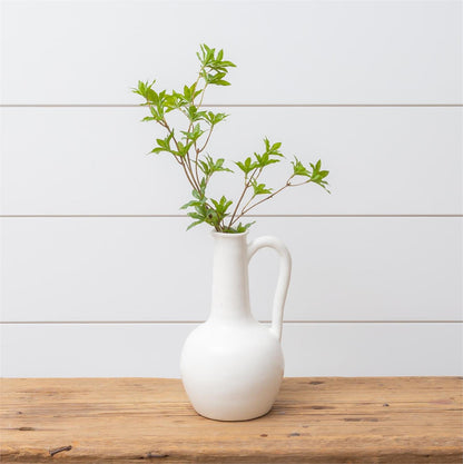 White ceramic long neck pitcher with green leaf stem not included.