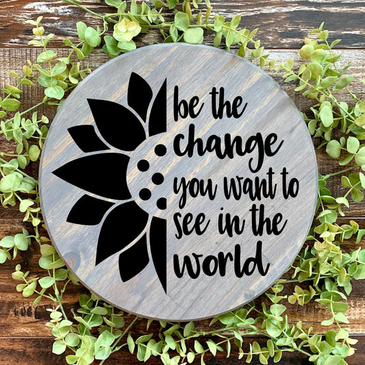 Be the change you want to see in the world round sign. Weathered Gray with black font 